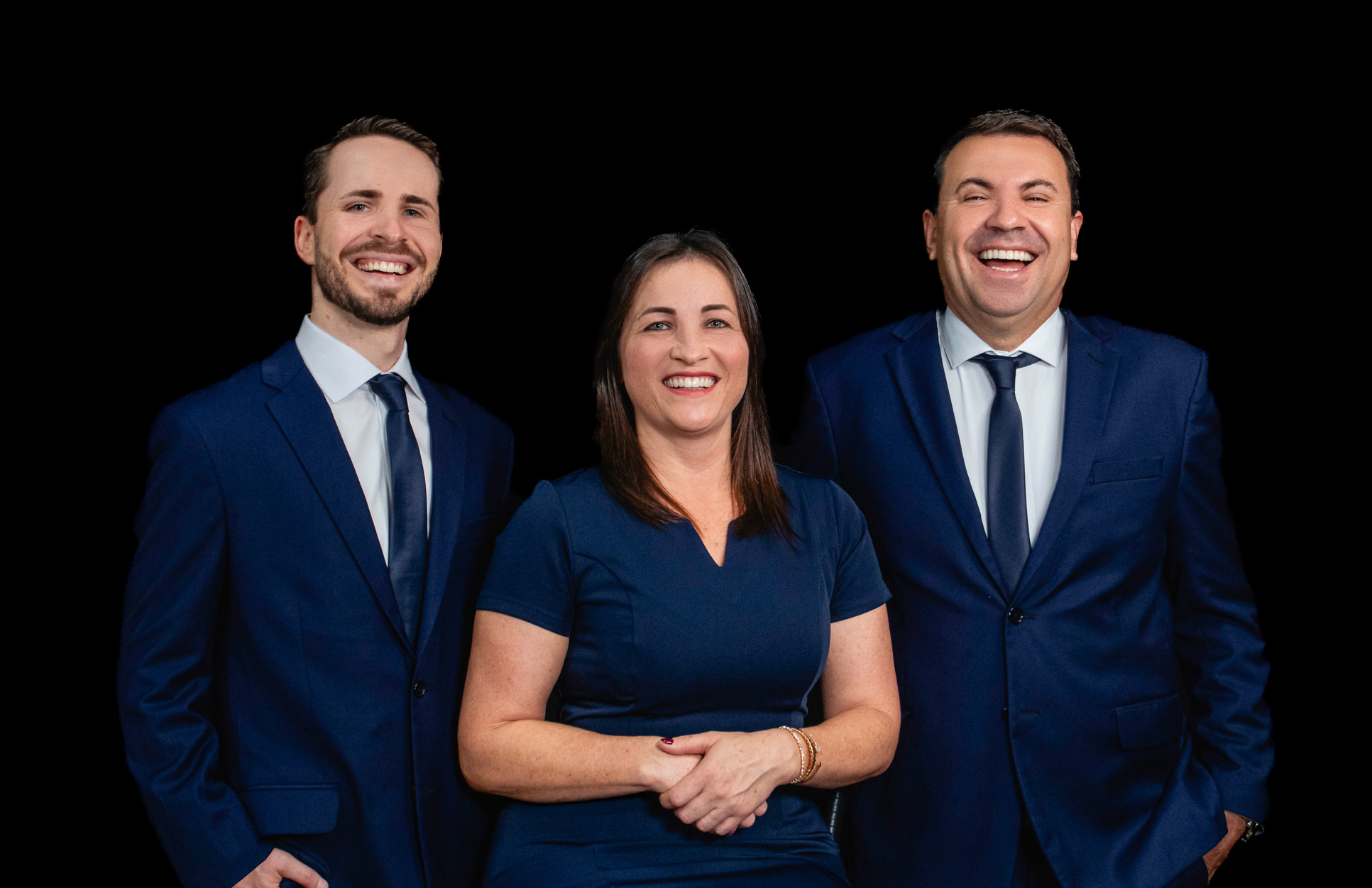 Três profissionais em retrato de equipe sobre fundo preto